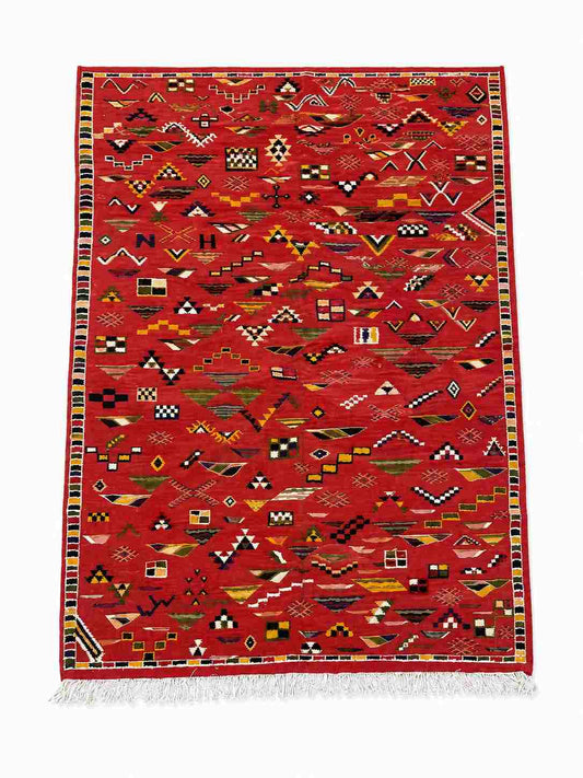 Tapis Akhnif rouge à champ de symboles berbères et bordure damier, poils ras, vue de dessus